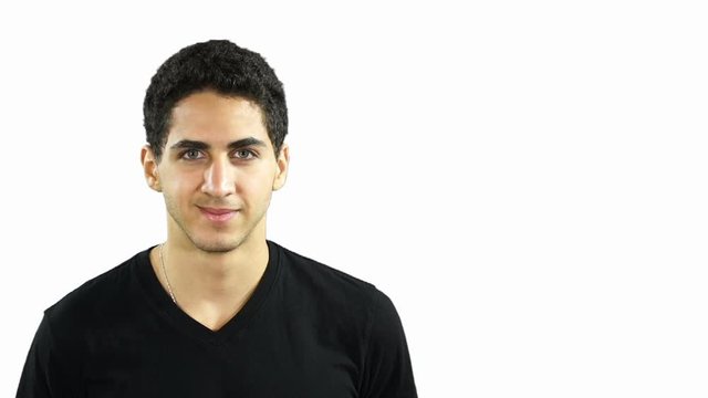 Young Middle Eastern man Looking at the camera - He is smiling with a White Background - Copyspace - Stock Video Clip Footage