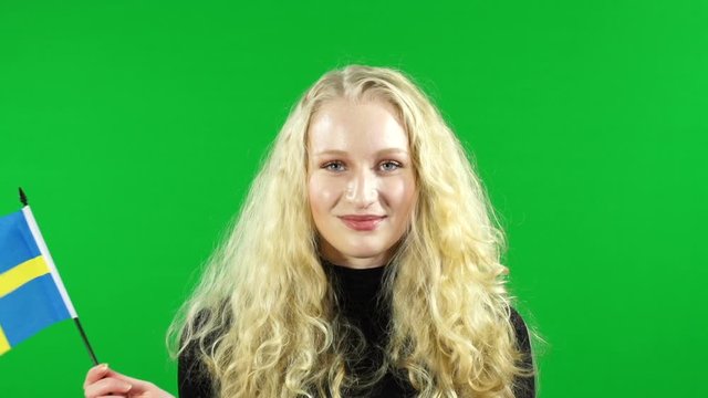 Young Girl waving Sweden hand Flag in front of Green Screen, Chroma Key Background - Swedish Stock Video Clip Footage