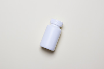 White plastic medical container for pills on yellow background