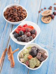 dried fruits in a white plate on a blue wooden background.
