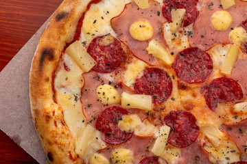 Delicious fresh pizza on table. pizza Hawaiian with pineapple and ham. Homemade delicious italian pizza on wooden table for dinner. Italian cuisine