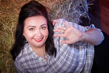 Portrait of fat plump fun charming cute woman with black hair in the room with hay and straw