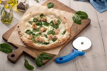 Delicious fresh pizza on table. Rustic pizza with minced meat cheese, basil on top. pizza with meat and basil. Homemade delicious italian pizza on wooden table for dinner. Italian cuisine.