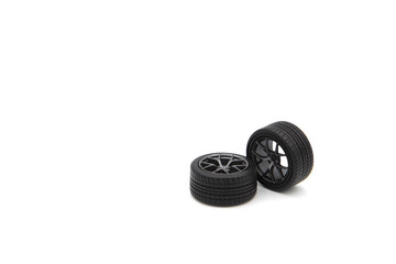 Two alloy wheels with tires of car model plastic kit isolated on white background.