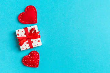Top view colorful valentine background made of gift boxes and red textile hearts. Valentine's Day concept with copy space