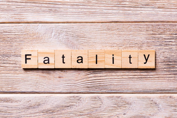 fatality word written on wood block. fatality text on wooden table for your desing, coronavirus concept top view