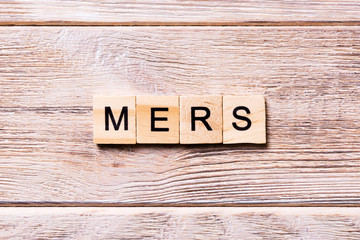 MERS word written on wood block. MERS text on wooden table for your desing, coronavirus concept top view