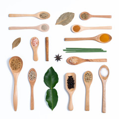 Various spices in wooden spoons, isolated background