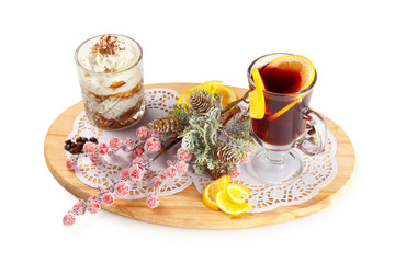Sponge dessert in a glass and mulled wine decorated with branches and citrus on a wooden board isolated on white background