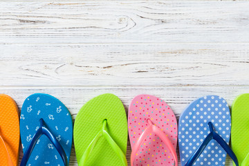 a lot of flip flop colored sandals, summer vacation on wooden background, copy space top view