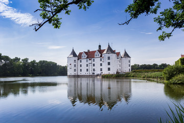 Naklejka na ściany i meble Historic castle with reflection in the lake in Glucksburg, Germany