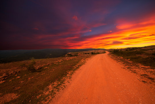 A multicolored sunset on a road in Valdelinares