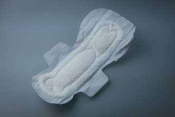 Side view of women sanitary pad on grey background.