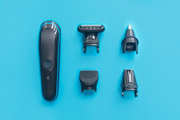 Men still life, flat lay. Composition, set for shaving. Electric razor trimmer with different nozzles for cutting mustache, beard and nose hair. Top view. Kit for male hairstyle. Home barbershop.