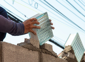 Construction worker put glass block brick to build the wall in construction site