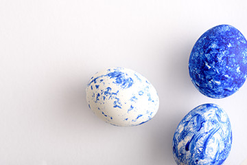 three Easter eggs in the color of the year-classic blue with a gradient effect on white background