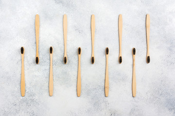 Zero waste eco friendly bamboo toothbrushes on white table, top view, selective focus