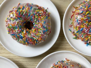 Fresh sweet donuts on the plates, top view 