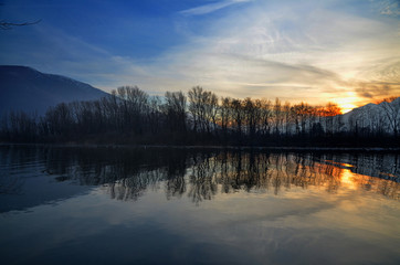 Sunset over an Alpine Lake with Mirror Image and Mountain in Switzerland.