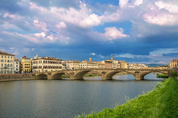 Obraz na płótnie Canvas View of bridge in Florence during sunset - Ponte alla Carraia, five-arched bridge over Arno River in the Tuscany region of Italy. Beautiful blue with pink sky with clouds. 