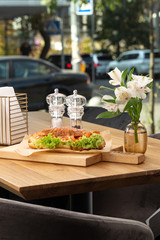 Croissant with smoked salted salmon, tomato, spinach and arugula. Croissant sandwiches served on wooden board. Croissants with egg, melted cheese, parsley, chicken ham, smoked salmon.