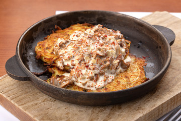 Potato pancakes with sour cream, herbs and garlic. Potato pancakes fried in butter. Potato pancake 