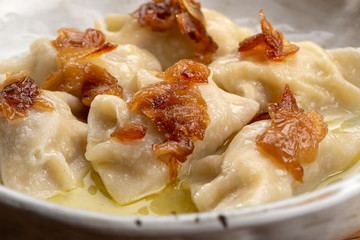 Pierogi, dumplings served with caramelized salted onion in bowl. Traditional Polish dish - pierogi...