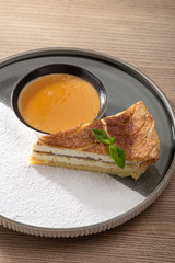 Tasty homemade cheesecake. Cheesecake with caramel cream on white plate on wooden table.