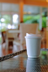 take away cup for hot coffee drink put on glass table in cafe shop