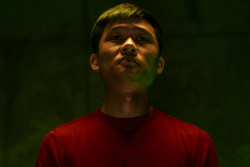 Sad and tired Asian man dark portrait