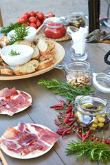 Platos de jamón serrano con pan y ilotas en mesa mediterranea