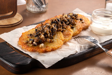 Potato pancakes with sour cream, herbs and garlic. Potato pancakes fried in butter. Potato pancake 