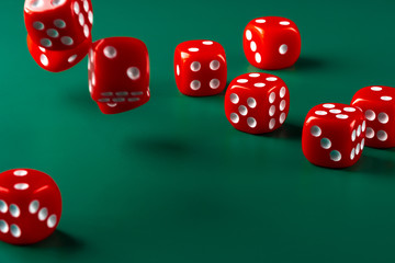 Red dice on green background close up