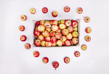 red apples in a box in the shape of a heart
