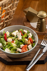 Delicious fresh salad. Greek salad with feta cheese, organic olives, juicy tomatoes, red pepper, red onion, cucumber and lettuce. Greek salad with fresh vegetables. Close up view on Salad. Healthy, di