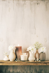 White flowers in neutral colored vases and candles