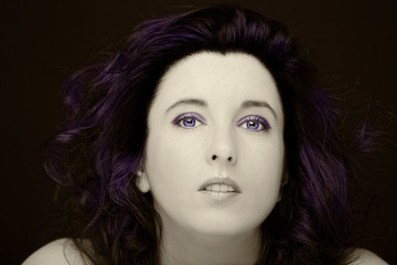 Young attractive woman with long black hair on dark background