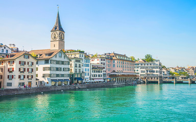 Fototapeta na wymiar Zurich city center and Limmat quay in summer with Cathedral and city hall clock towers spires in summertime