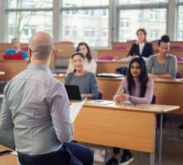 Lecturer and multinational group of students in an auditorium