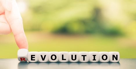 Evolution instead of revolution. Hand turns a dice and changes the word 