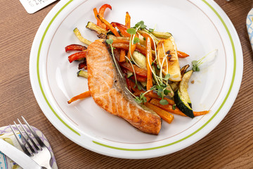 Salmon steak with vegetables. Grilled salmon steak with lemon and vegetables. Fish meal with fresh vegetable.