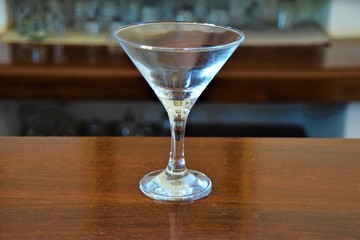 Empty martini glass on bar counter closeup