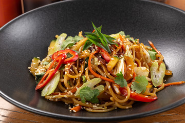 Stir fry with soba noodles, vegetables. Asian healthy food, stir fried meal in bowls. Spicy noodles. Vegetarian Noodles or Vegetable Hakka Noodles or Chow Mein. Indo-chinese cuisine hot dish