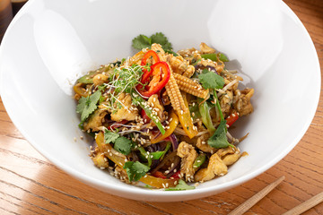 Spicy asian salad. Thai salad with greens, vegetables. Asian salad with chili, corn, cucumber, carrot, onion, soy, popular in the country Thailand. Indo-chinese cuisine hot dish with vegetables and ch