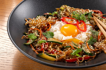 Thai food fried rice with egg. Asian cuisine-Homemade egg fried rice served with vegetables. Fried rice with vegetables, pepper, carrot, cucumber, parsley, onion, eggs, chilli. Indo-chinese cuisine