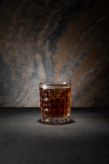 glass with beer on textured granite background