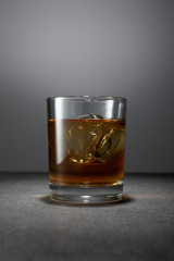 ice cubes in alcohol drink on grey background