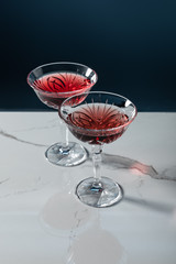 glasses of red wine on marble surface isolated on blue