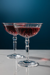 glasses of red wine on white marble surface isolated on blue