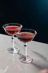 red wine in glasses on white marble surface isolated on blue